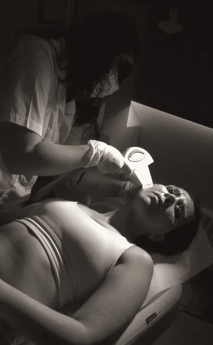 Ghazaleh performing a specialized facial treatment, black and white